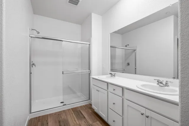 a bathroom with a shower sink and mirror