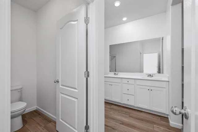 a bathroom with a granite countertop toilet a sink and a mirror