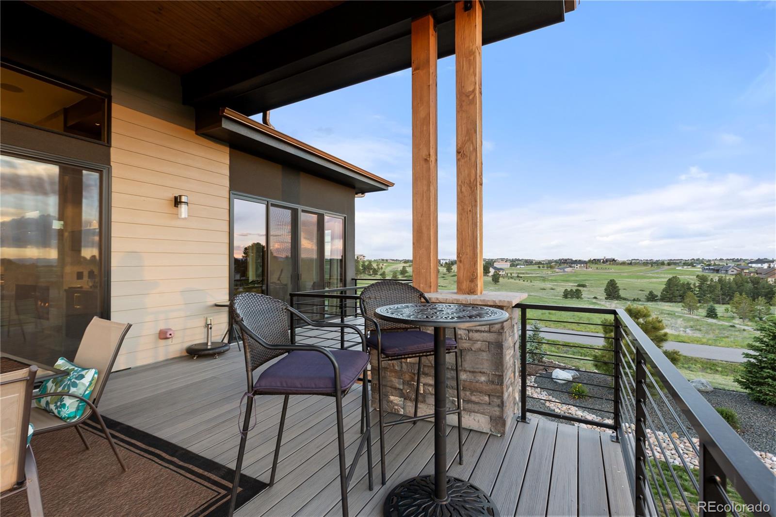 10689 Shadow Pines Road Parker, CO 80138 - Photo 31 of 50 a view of a balcony with table and chairs and wooden floor