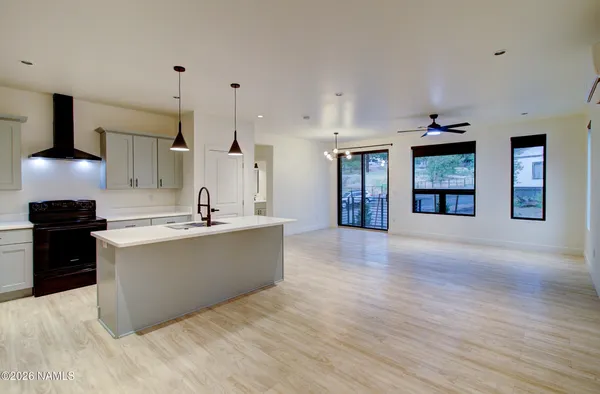 a large kitchen with a lot of cabinets and wooden floor