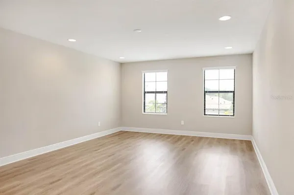 a view of an empty room with wooden floor