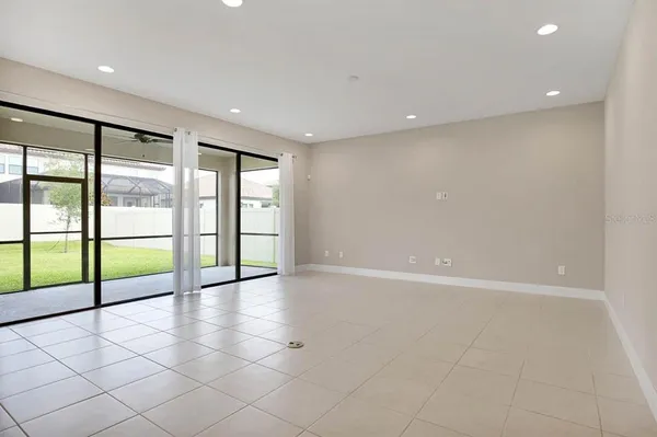 a view of a kitchen with refrigerator and white cabinets