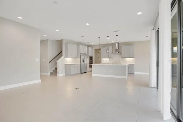 a kitchen with stainless steel appliances granite countertop a refrigerator a sink and white cabinets
