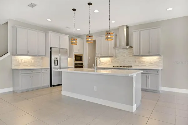 a view of kitchen with stainless steel appliances cabinets a sink and a refrigerator