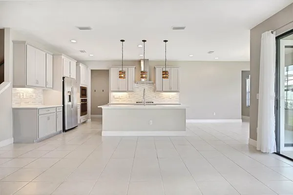 a kitchen with stainless steel appliances granite countertop a sink a stove and a refrigerator