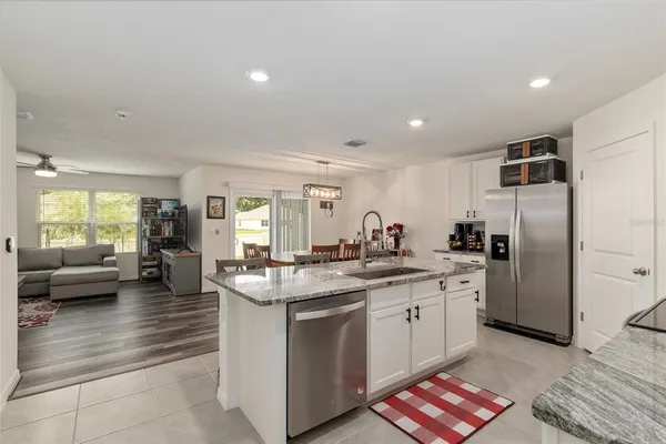 a kitchen with granite countertop white cabinets and stainless steel appliances