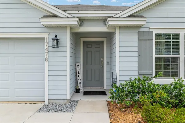 a living room with furniture a flat screen tv and a floor to ceiling window