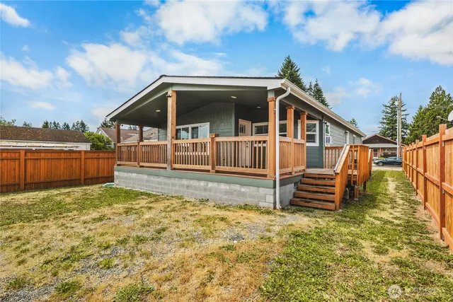 a view of a house with backyard and wooden fence