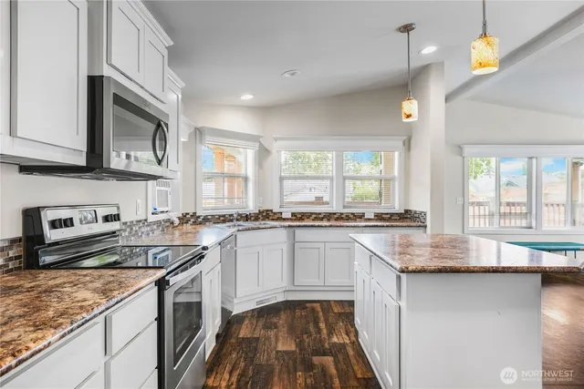 a kitchen with stainless steel appliances granite countertop a sink stove and cabinets