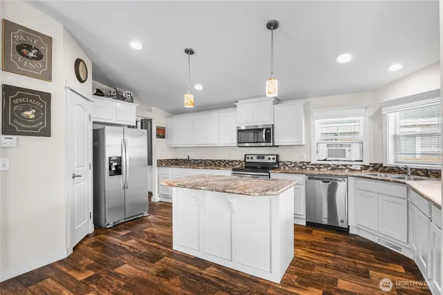 a kitchen with stainless steel appliances granite countertop a refrigerator a stove a sink and a microwave