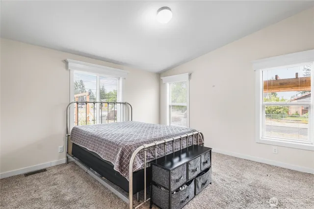 a bedroom with a bed next to a window