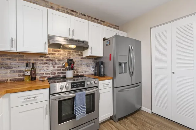 a kitchen with stainless steel appliances granite countertop a refrigerator sink and stove