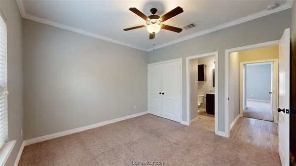 an empty room with closet and a ceiling fan