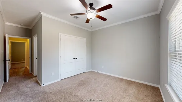 an empty room with windows and fan