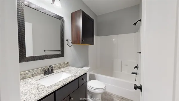 a bathroom with a granite countertop sink toilet and shower