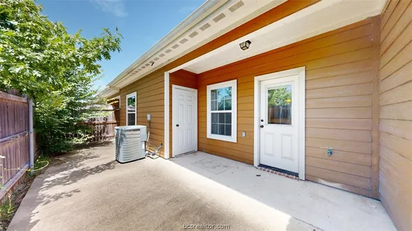 a view of a brick house with a yard and potted plants
