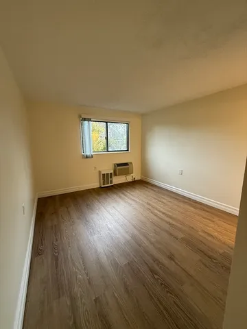 a view of a room with wooden floor and window