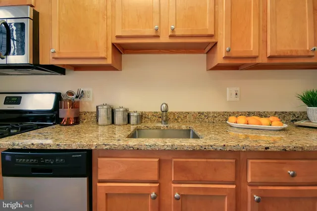 a kitchen with granite countertop a sink and cabinets