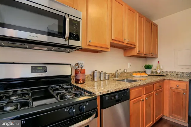 a kitchen with stainless steel appliances granite countertop a stove and a microwave