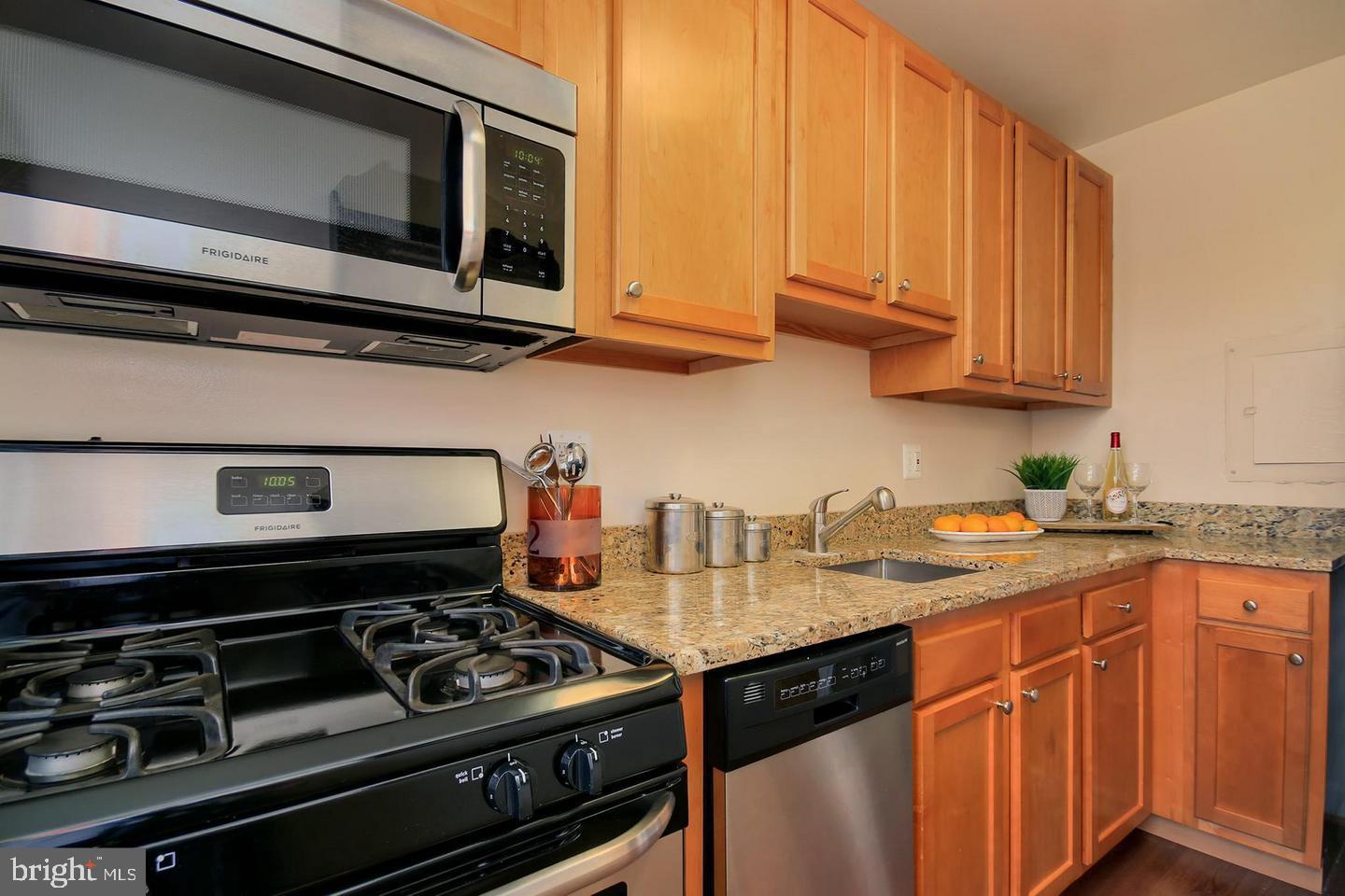 2712 Ordway Street Northwest, Unit 5 Washington, DC 20008 - Photo 13 of 26 a kitchen with stainless steel appliances granite countertop a stove and a microwave