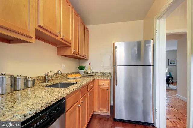 a kitchen with stainless steel appliances granite countertop a refrigerator a sink and a stove
