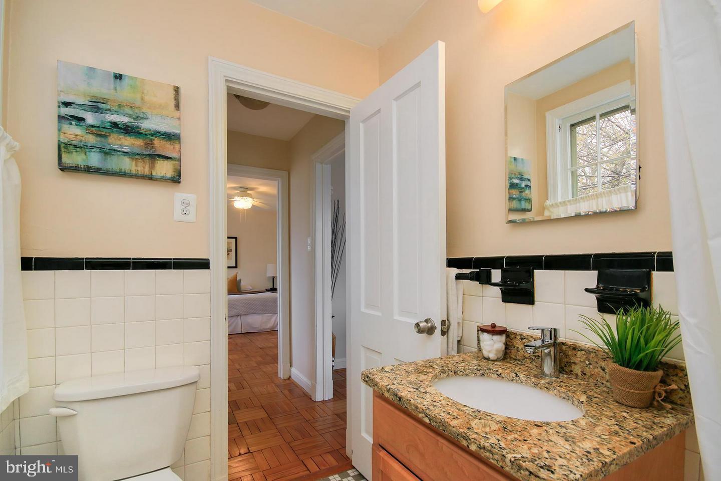 2712 Ordway Street Northwest, Unit 5 Washington, DC 20008 - Photo 17 of 26 a bathroom with a granite countertop sink a mirror and shower