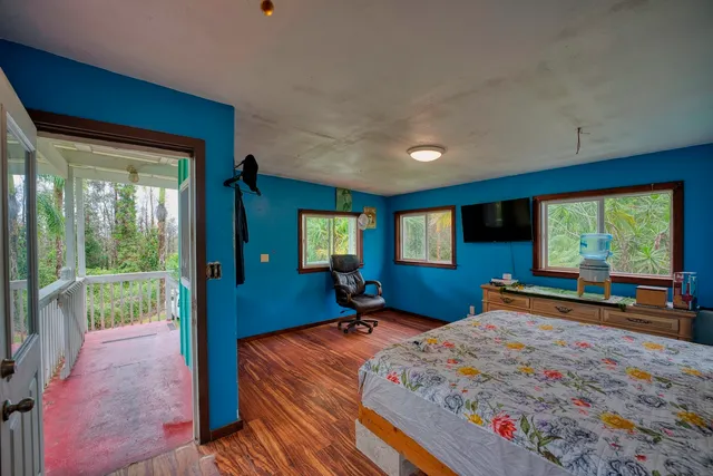 a bedroom with a bed and large windows