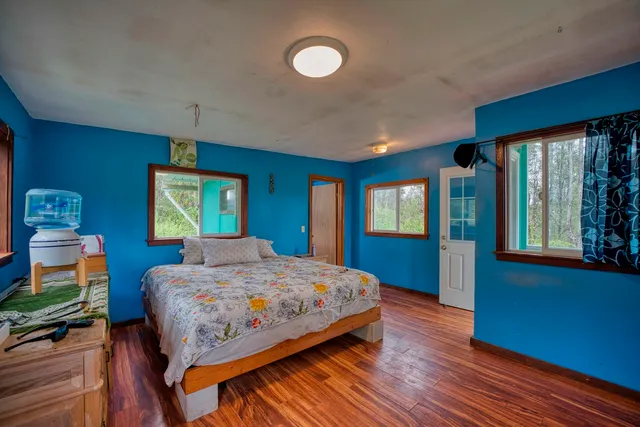 a bedroom with a bed and a dresser next to a window