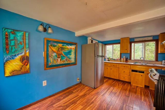 a large kitchen with stainless steel appliances granite countertop a stove a sink and a large window