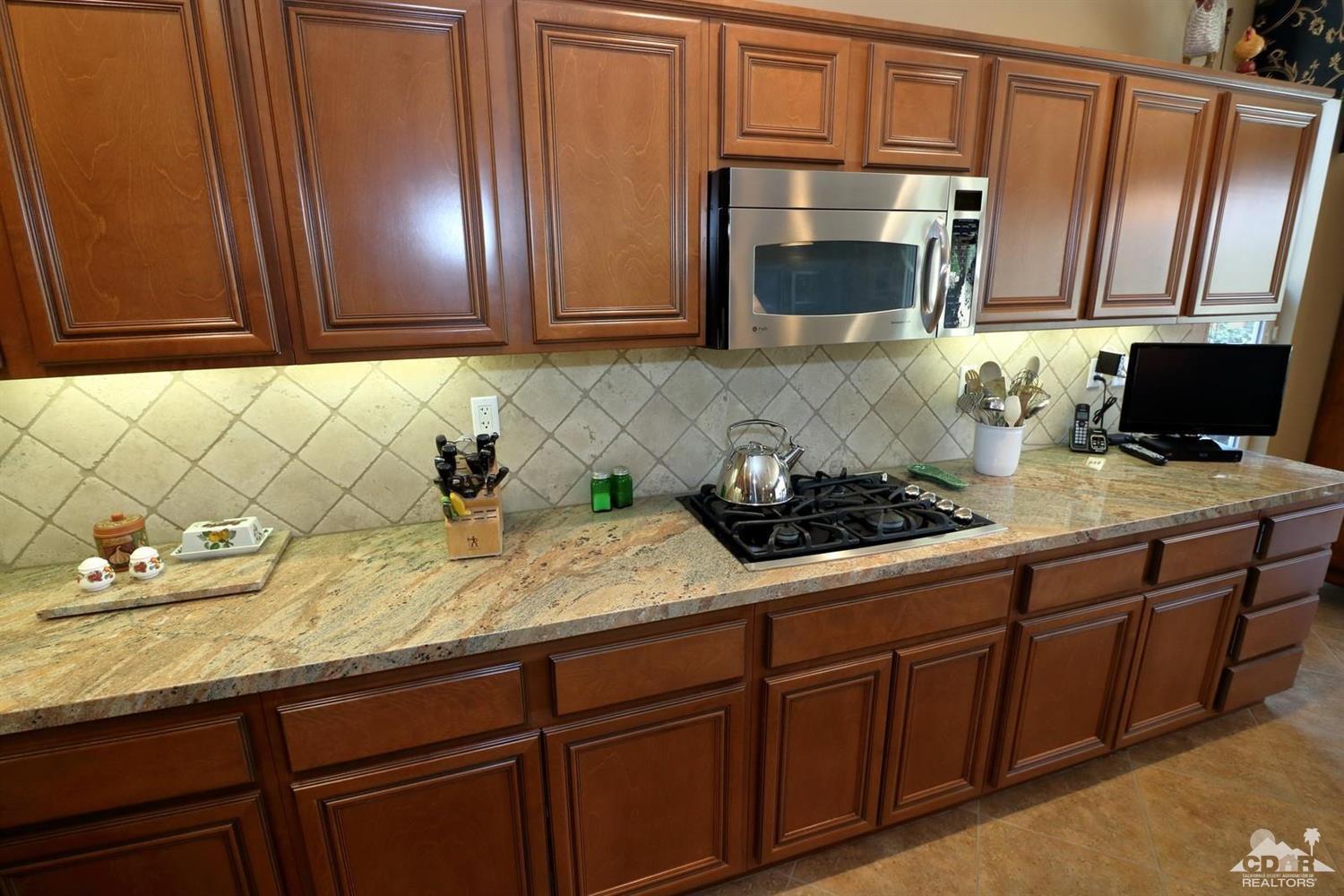 81757 Rustic Canyon Drive La Quinta, CA 92253 - Photo 13 of 40 a kitchen with stainless steel appliances granite countertop a sink a stove and cabinets