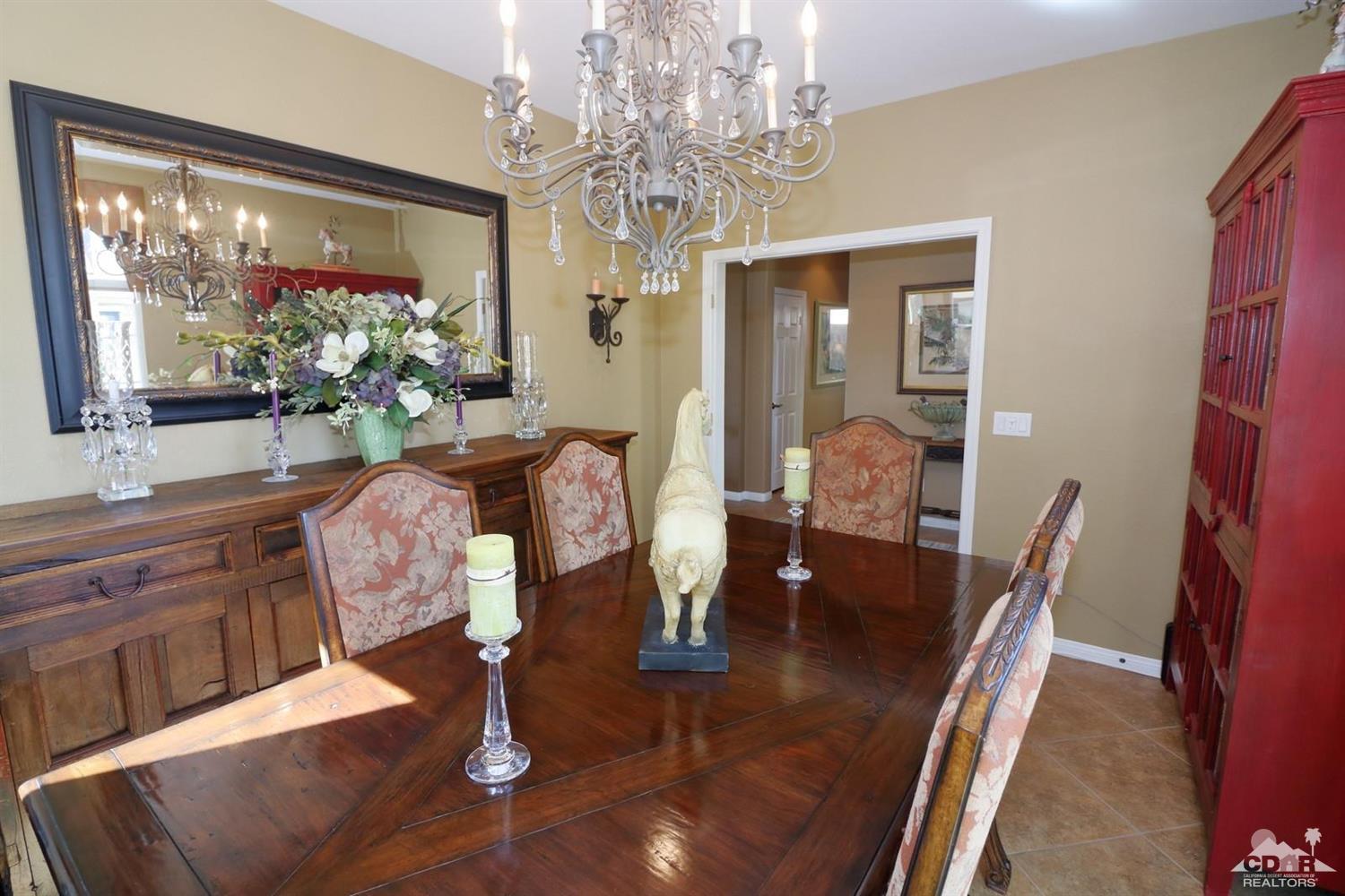 81757 Rustic Canyon Drive La Quinta, CA 92253 - Photo 21 of 40 a dining room with furniture a large window and wooden floor