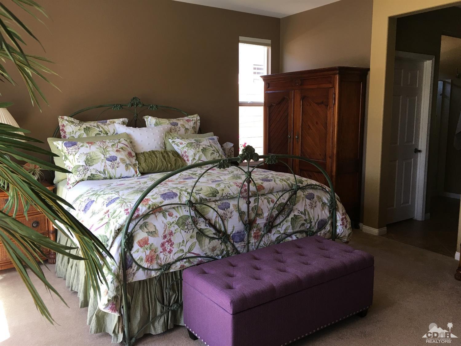 81757 Rustic Canyon Drive La Quinta, CA 92253 - Photo 22 of 40 a bed sitting in a bedroom next to a wooden closet