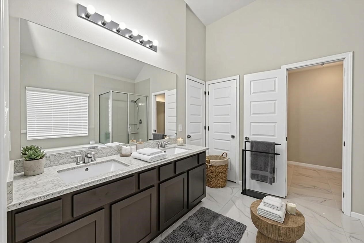 22409 Kinley Street New Caney, TX 77357 - Photo 6 of 46 a bathroom with a double vanity sink a toilet and a mirror