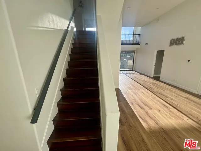 a view of a hallway with wooden floor and entryway