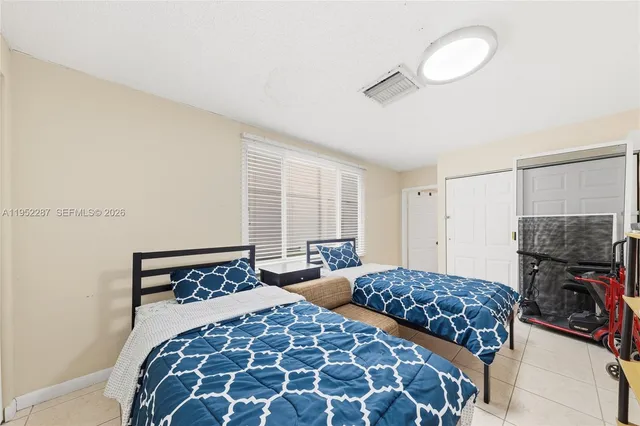 a bedroom with two beds and a chandelier