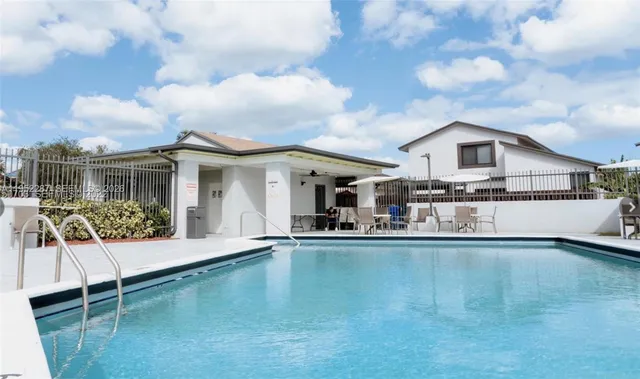 a view of a house with pool and chairs