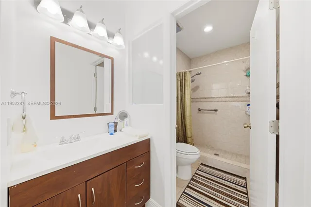 a bathroom with a sink a toilet a shower and a mirror