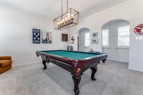 a room with pool table and windows