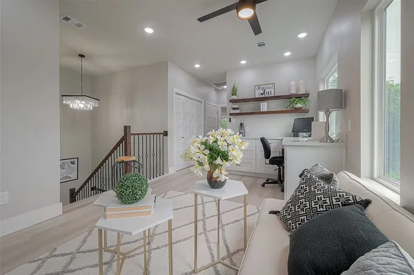 a living room with furniture flowerpot and wooden floor