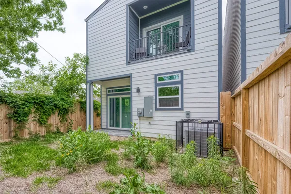 a view of a house with potted plants and a table and chair