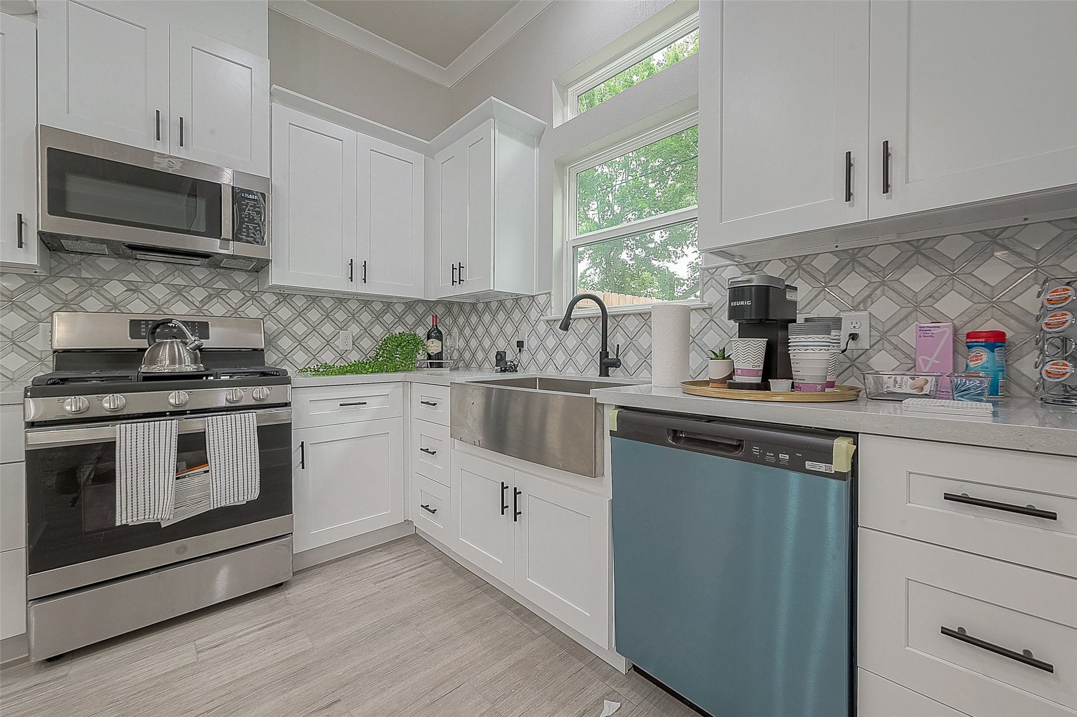 7108 St Augustine Street Houston, TX 77021 - Photo 5 of 21 a kitchen with white cabinets appliances a sink and a window