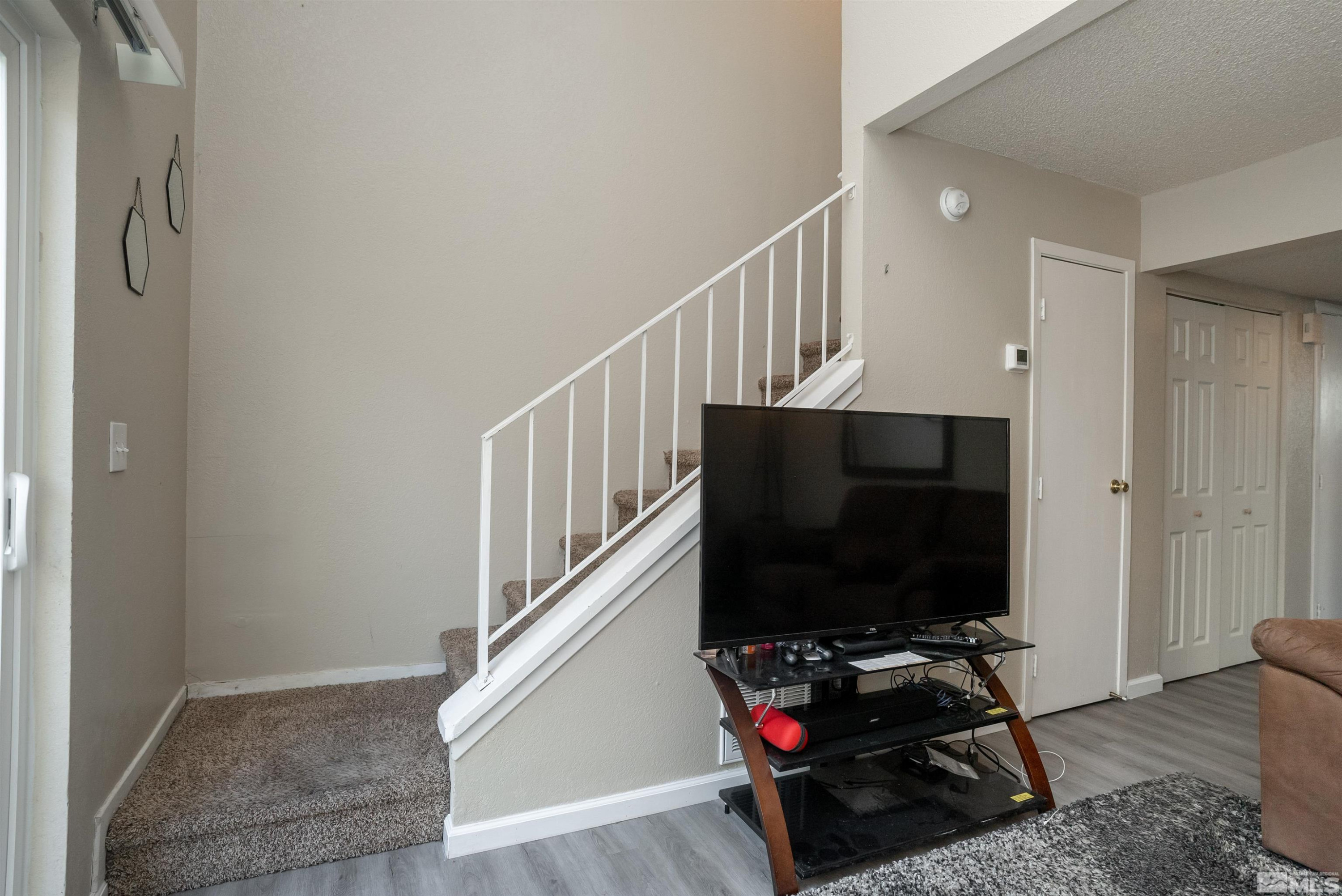 13864 Lear Boulevard Reno, NV 89506 - Photo 17 of 31 a living room with wooden floor and a flat screen tv