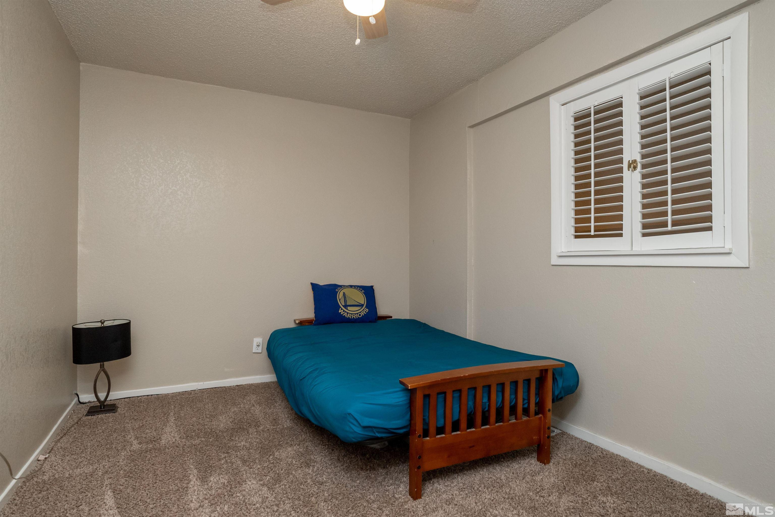 13864 Lear Boulevard Reno, NV 89506 - Photo 18 of 31 a bedroom with a bed and a window