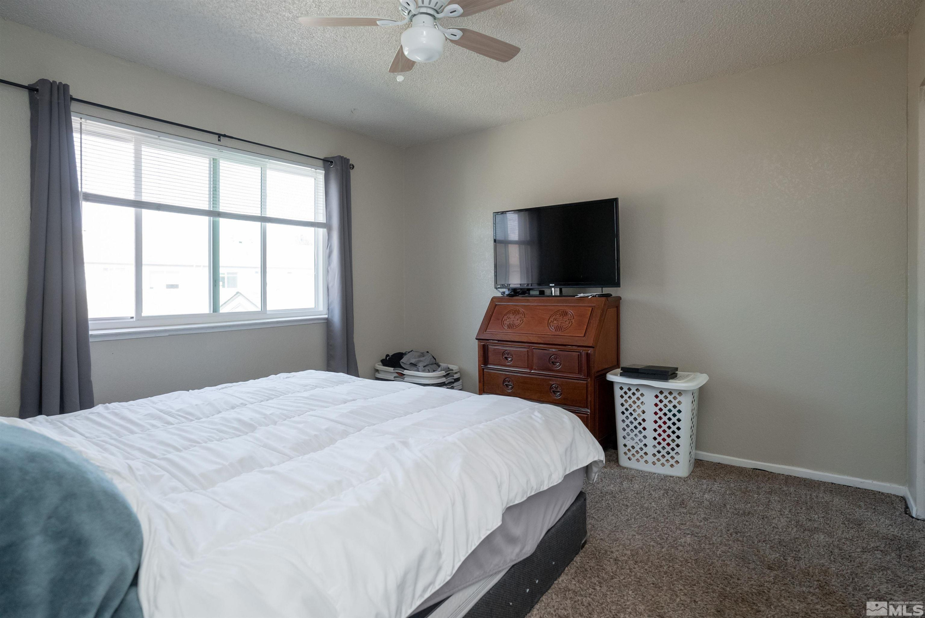 13864 Lear Boulevard Reno, NV 89506 - Photo 23 of 31 a bedroom with a bed and a flat screen tv