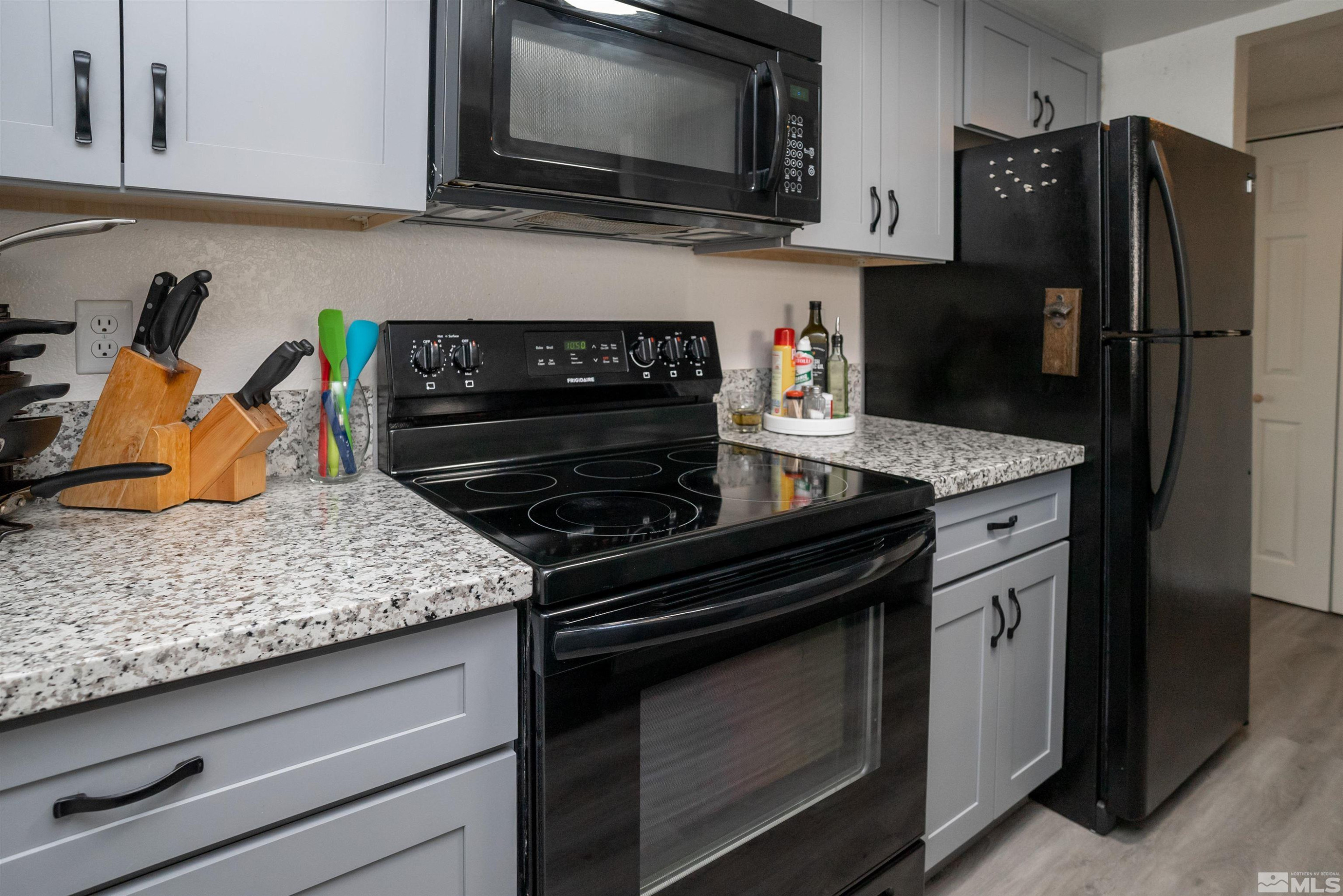 13864 Lear Boulevard Reno, NV 89506 - Photo 6 of 31 a kitchen with stainless steel appliances granite countertop a stove microwave and refrigerator