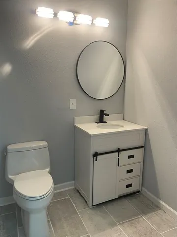 a bathroom with a toilet a sink and a mirror