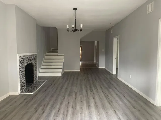 a view of a livingroom with a fireplace wooden floor and staircase