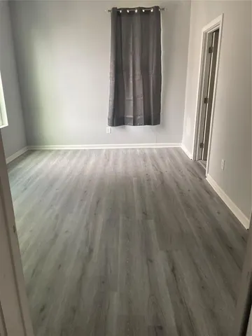 an empty room with wooden floor and a window