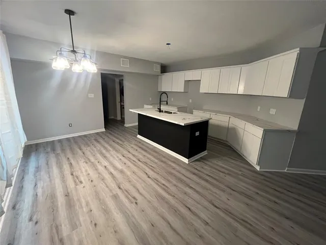 a view of kitchen with granite countertop cabinets and wooden floor