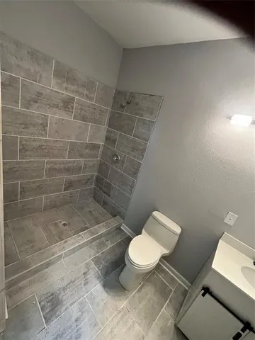 a bathroom with a toilet and a shower